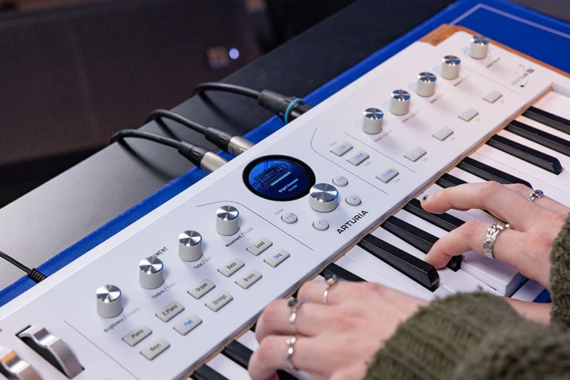 A girl playing a digital piano keyboard at a wooden desk in a home musica practice space