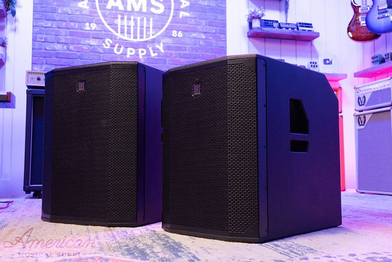 Alt tag:	Wall-mounted white indoor speaker with a perforated grille, installed below a slatted wood ceiling.