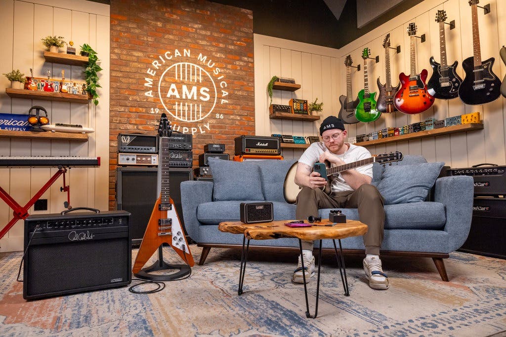 Guitarist playing a guitar on the couch.
