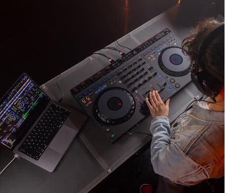 Alt tag:	A DJ wearing headphones uses a mixing board