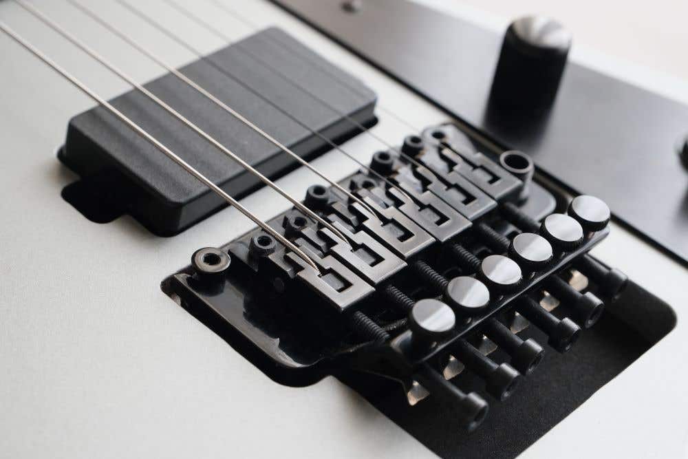 Floyd Rose locking tremolo guitar bridge on white guitar with active pickups