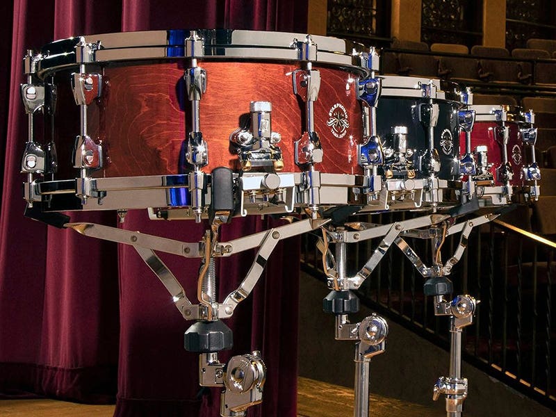 Three snare drums on stands.